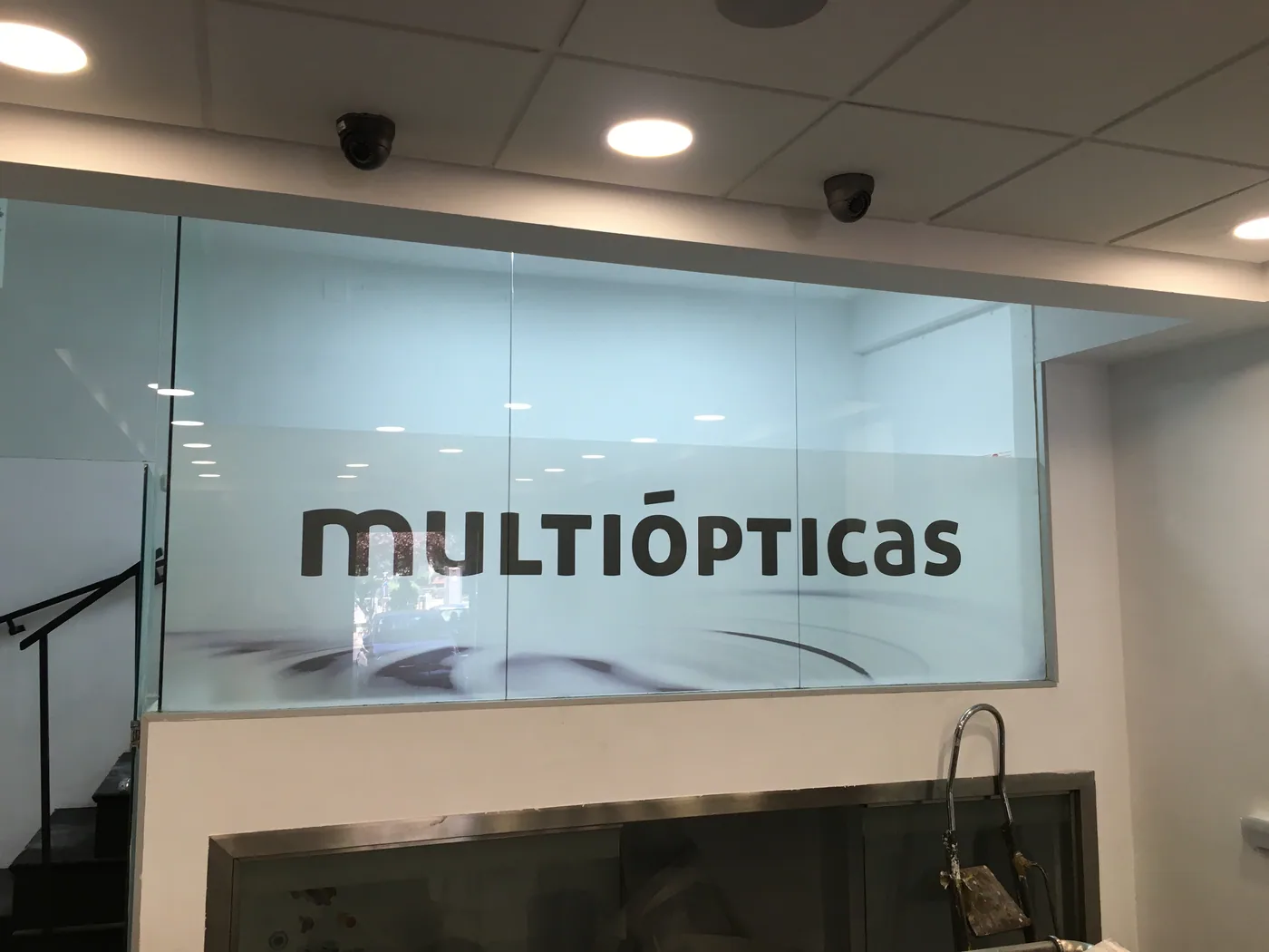 Mampara de vidrio con vinilo efecto ácido y el logotipo de Multiópticas reservado