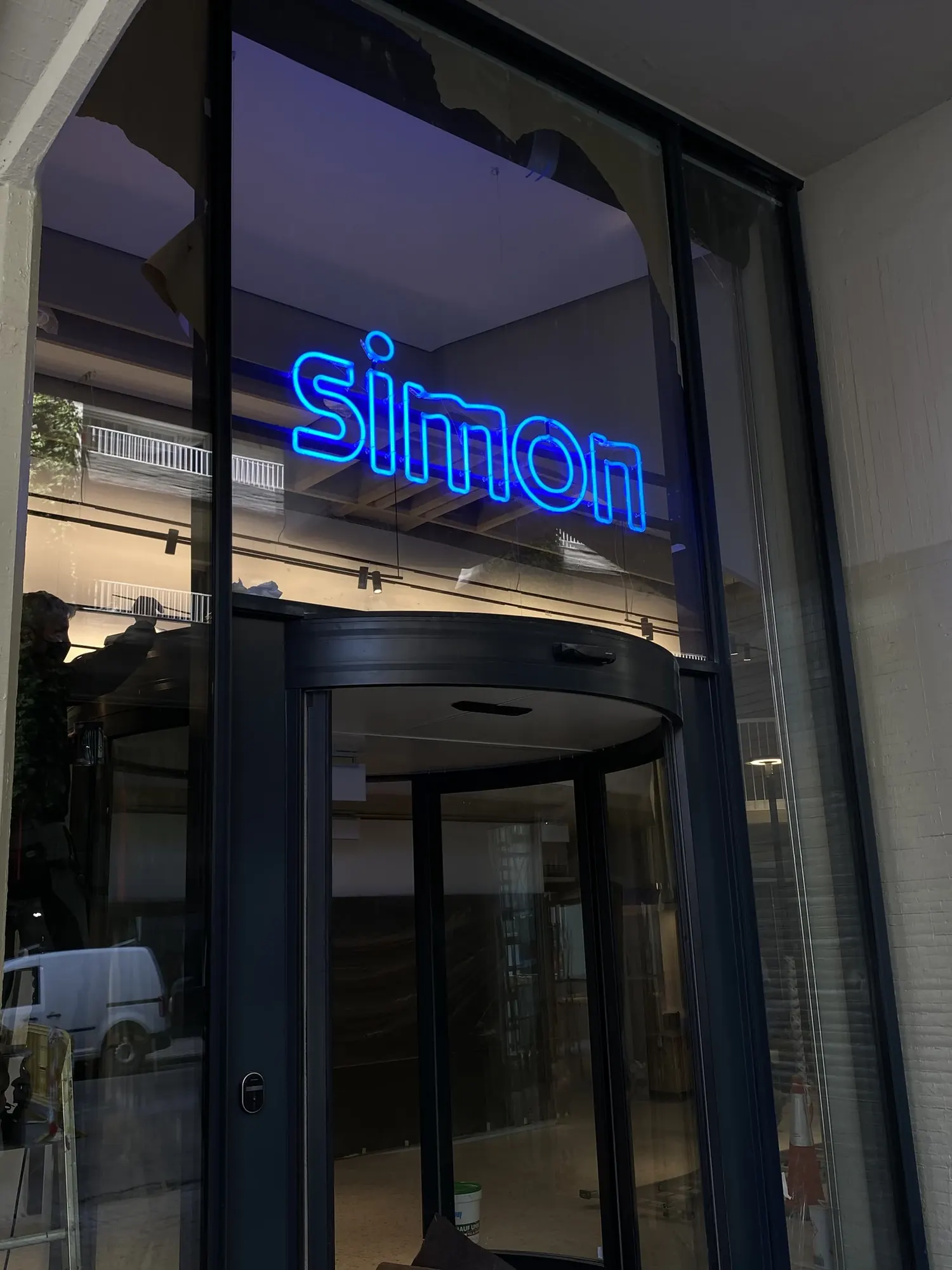 Rótulo de neón azul de Simon encendido sobre la fachada acristalada del local de la calle San Bernardo