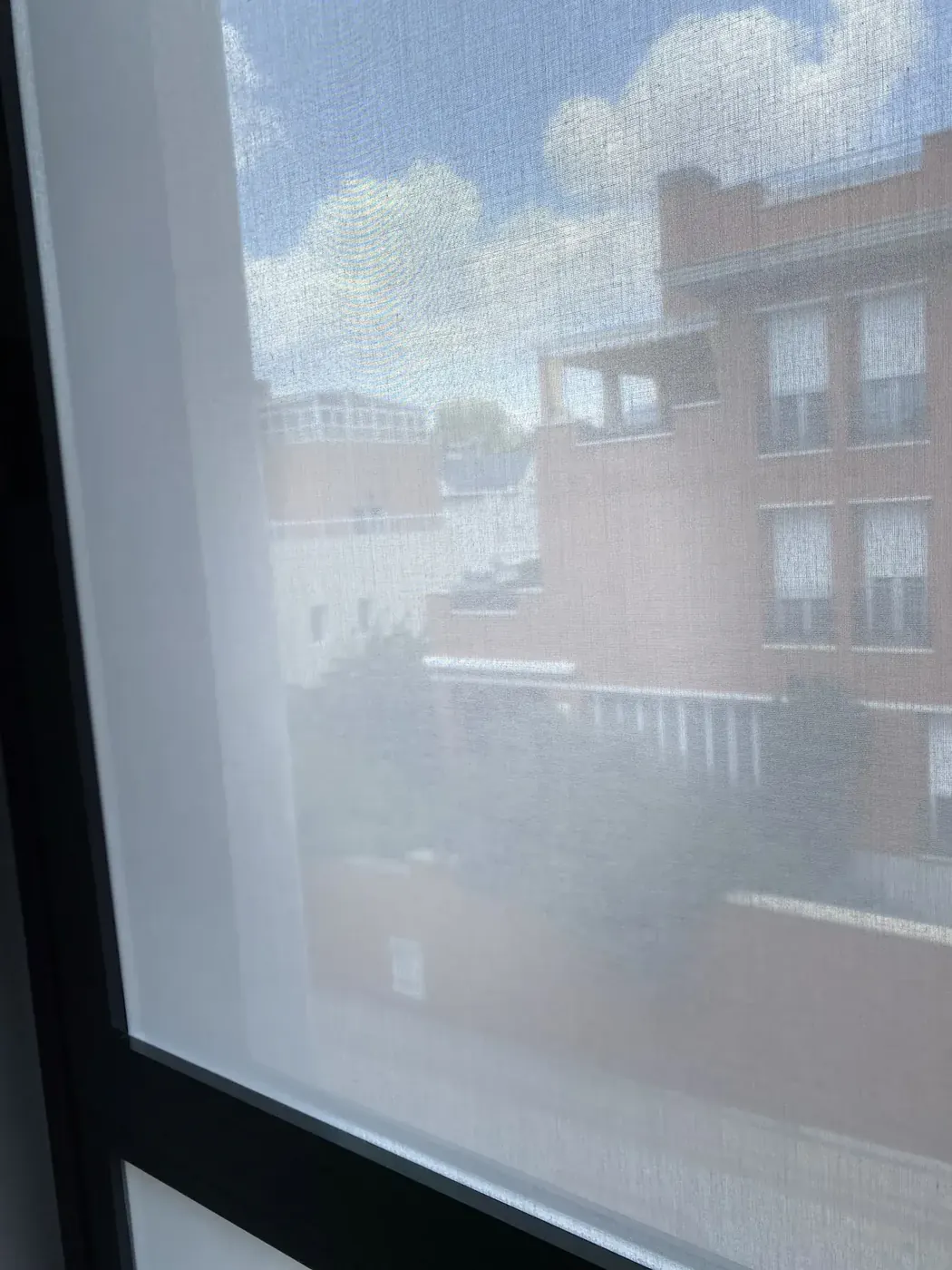 Ventana de vivienda con vinilo textil que difumina la vista al exterior