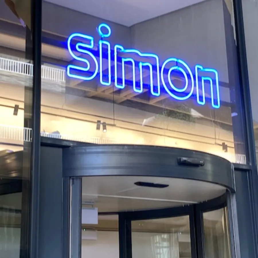Simon · Madrid — neón sobre fachada de vidrio